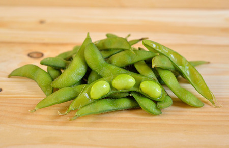 boiled green soybeans on wooden tableの写真素材