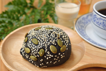 tuna chicken charcoal bun on wooden plate with a cup of coffeeの写真素材