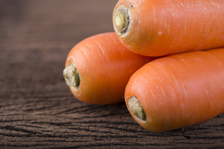 pile of fresh carrots on wooden backgroundの写真素材