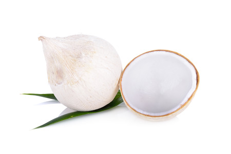 whole and half cut young coconut with leaf on white background