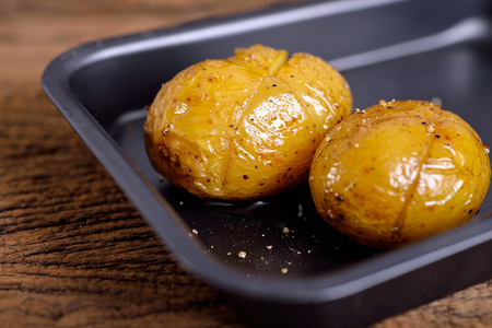 grilled potato with black pepper in pan on wooden backgroundの写真素材