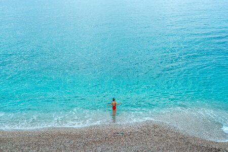 Image of a beautiful young woman standing copy space isolated over blue sea background. A girl is...