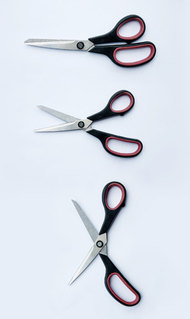 Three open pair of scissors ready to cut