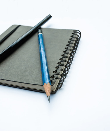 Blank note book with pencils isolated on white background