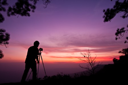 Photographer on sunset background imageの写真素材