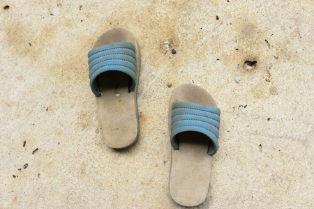 Old chindren shoes is dirty with ground backgroundの写真素材