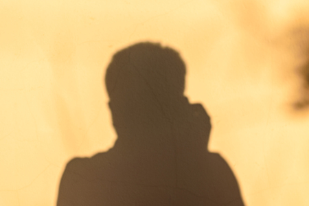 dark shadow man in the house wall, brown wall backgroundの写真素材