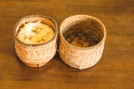 rice box open lid ,put on the wooden table , show olden it, Rice box put sticky rice in box for eating, lifestyle Thailandの写真素材