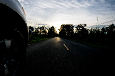 car is driving on road country,image show in front of car on the road, in the evening, Thailandの写真素材