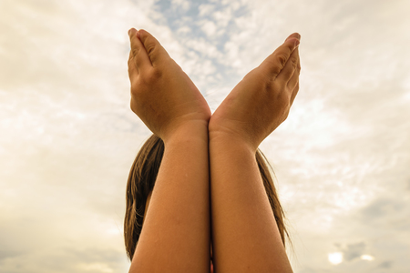 girl show her hands,closing her face,close up image,and clouds backgroundの写真素材