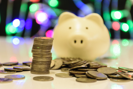 a container for saving money in, especially one shaped like a pig, with a slit in the top through which coins are rich,piggy bank on wooden blurring dot color backgroundの写真素材