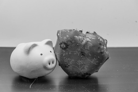 piggy bank and pink heart is isolated ,with hand safe coin for piggy bank,black and white background isolated,piggybank is a container for saving money in, especially one shaped like a pig, with a slit in the top through which coins are droppedの写真素材