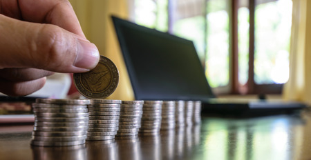 hands holding coins , are placed on the wood table,row upon row of reparations