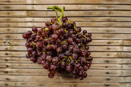 Purple grapes, fresh, delicious. Placed on a bamboo floor old indicate a fruit with vitamin a to...