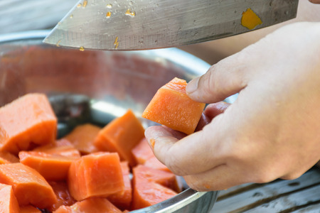 Hand sliced ripe papaya by knife with old wooden background,fruit for healthy,Look deliciousの写真素材