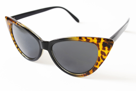 Sunglasses, women's fashion producer. The glasses have the shape of a cat's eye, dark glasses and black and brown leopard frames, white background.の写真素材