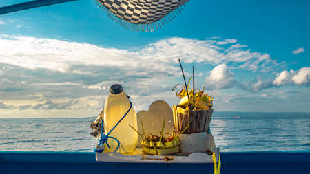 balinese offerings temple on the boat with the background of the sea-ocean and a sunny cloudy sky during the summer as a symbol of hope to God.の写真素材