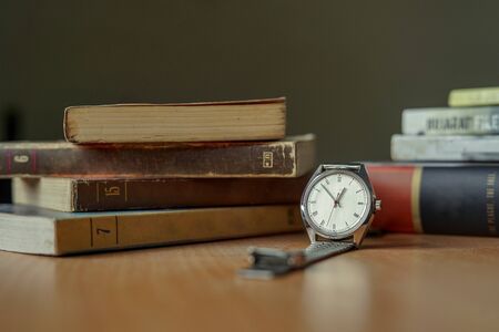 Old vintage watch and some books on a table