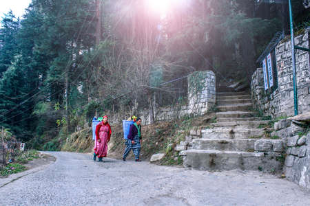 Manali, Himachal Pradesh/ India- June 14 2020: A view of two women carrying loads up in the...