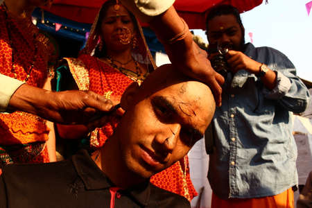Almora, uttrakhand / India - May 26 2020 : A close of a hand and a head while cutting hairs, indian...