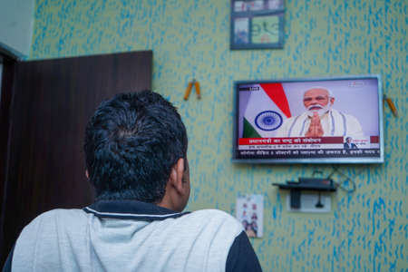 New delhi, Delhi/ India- June 30 2020: A man watching the live Tv of Prime minister Narendra Modi's announcement about Unlock India from corona virus at a house in New delhi.のeditorial素材