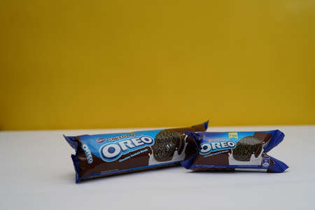New Delhi, Delhi/ India- July 2 2020: Two packets of oreo biscuits kept on a white paper with yellow background.のeditorial素材