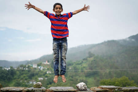 little indian kid jumping with joy on the roof