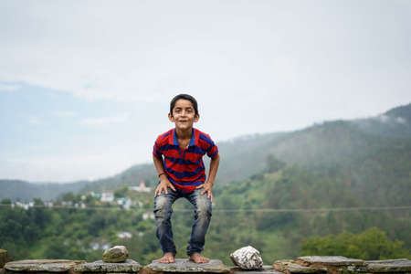little indian kid jumping with joy on the roof