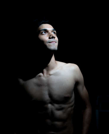 low key portrait of a young handsome man with awesome physique