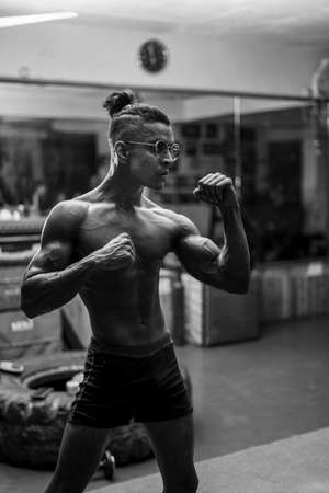 Young shredded and fit boy working out in the gym,standing in a boxing pose.の写真素材