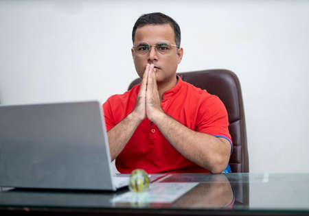 technology, remote job and lifestyle concept - happy indian man in glasses with laptop computer...