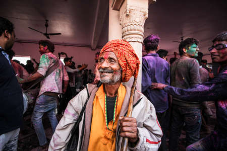 Mathura, Uttar Pradesh, India- January 28 2020: Portrait of an old man in turban covered in colors of holi, smiling into the camera. Man enjoying the moment during the festival of holi in mathura.のeditorial素材