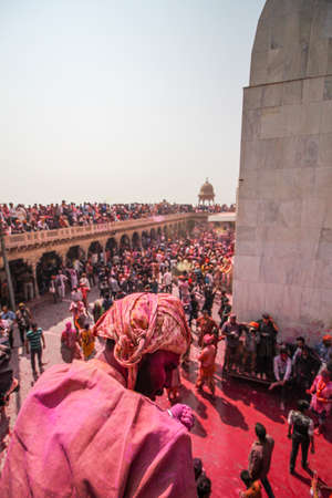 Mathura, Uttar Pradesh, India- January 28 2020: Young man peeing down the balcony in the nandgaon temple. People enjoying and playing with colors while celebrating the festival of Holi.のeditorial素材