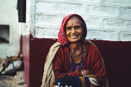 Almora, Uttrakhand - March 2 2021:- Old aged woman sitting with the support of the wall in the...