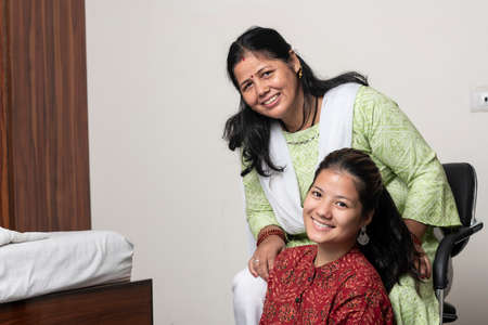 Portrait of a young indian girl having fun with her mother, posing towards the camera with her mother.の写真素材