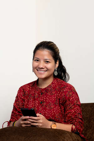 Portrait of a young beautiful indian girl looking into the camera, captured on a white isolated background.の写真素材