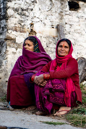 Almora, Uttarakhand - January 3 2022- Two indian elderly aged women sitting on the road and looking into the camera. Indian traditional women wearing indian clothes.のeditorial素材
