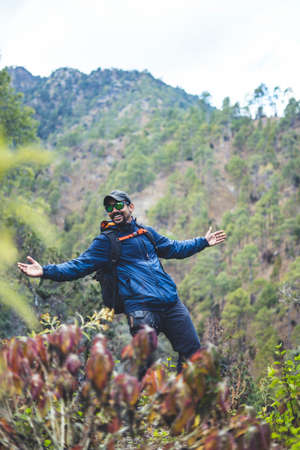 Hipster young boy with backpack enjoying trekking sunset on the mountains. Tourist traveler on...