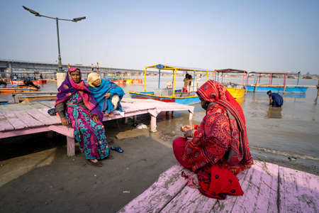 Garh Mukteshwar, Uttar Pradesh- January 13 2022 - Three women having a discussion about the next political party in india while sitting on the banks of ganges.のeditorial素材