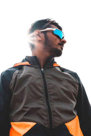 Portrait of a young indian sportsman wearing sports sunglasses looking towards right side. Sports...