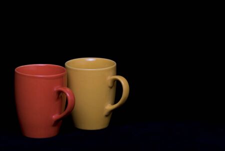 Isolated set of colourful coffee mugs on a black backgroundの写真素材