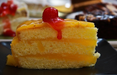 orange cake with cherry on topの写真素材
