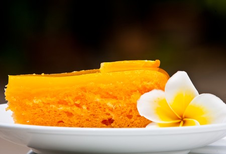 Orange cake with a white flower.の写真素材