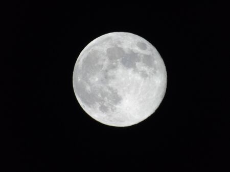 An amazing photography of the full moon over the city of Genoaの写真素材