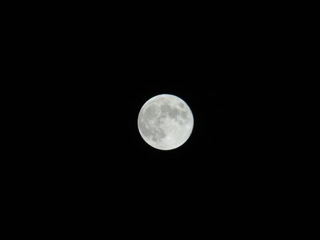 An amazing photography of the full moon over the city of Genoaの写真素材