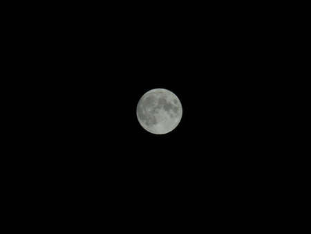 Genova, Italy - 07/05/2020: An amazing photography of the full moon over the city of Genova by night with a great clear and blue sky in the background and some stars.の写真素材