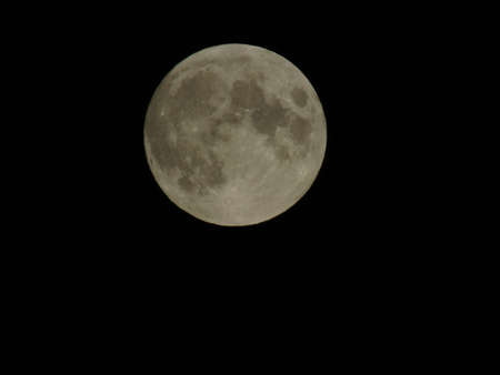 Genova, Italy - 07/05/2020: An amazing photography of the full moon over the city of Genova by night with a great clear and blue sky in the background and some stars.の写真素材