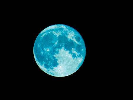 Genova, Italy - 07/07/2020: An amazing photography of the full moon over the city of Genova by night with a great clear and blue sky in the background and some stars.