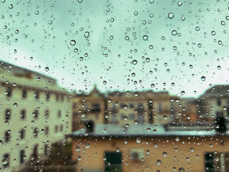 Beautiful photography of the waterdrop over the window. Indoor panoramic view to the city after...