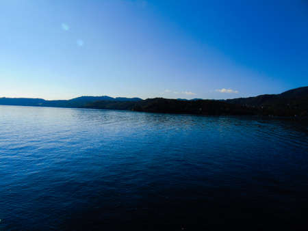 Liguria, Italy - 08/15/2020: Reflection of sunrise for blur background in summer days over the water. Clear blue sky hot climate in summer days.の写真素材